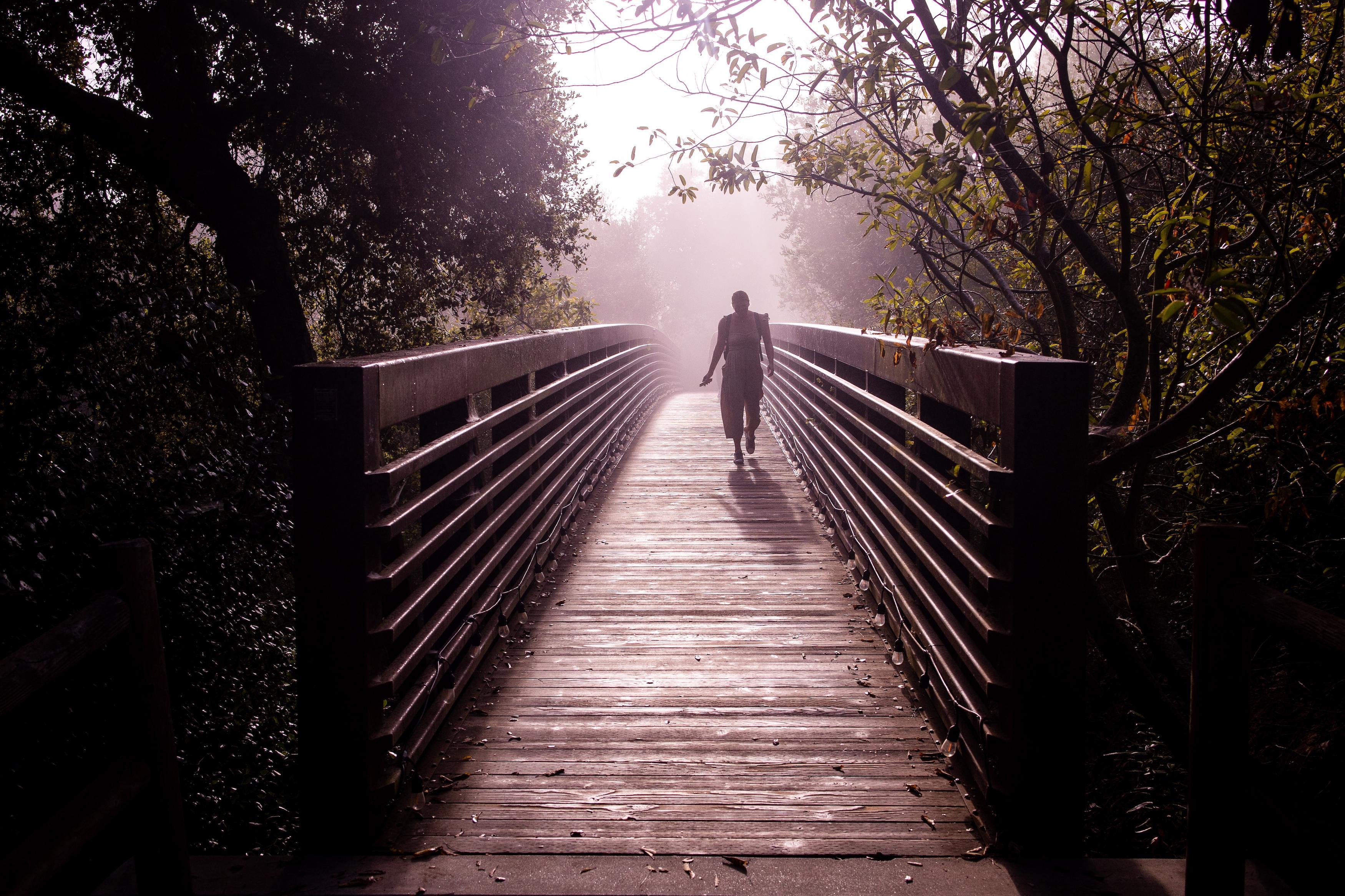 woman walking across westmont bridge in fog